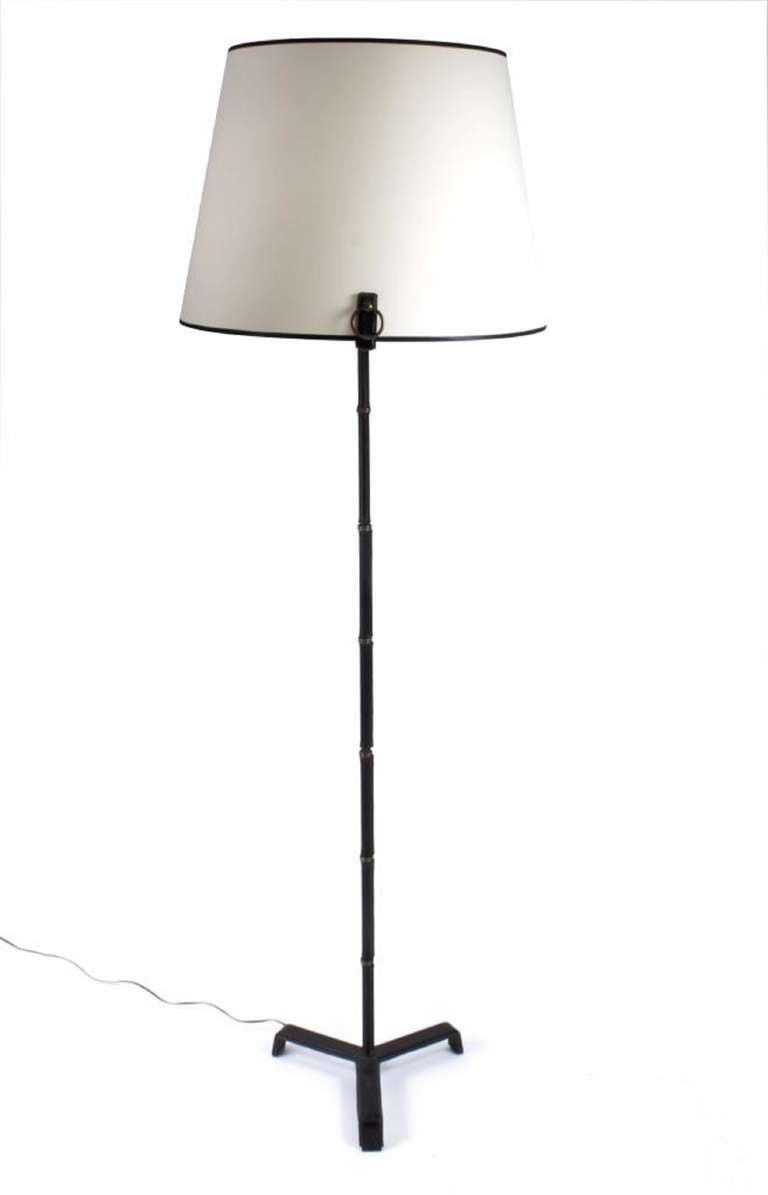 Floor lamp designed by Jacques Adnet circa 1955.  Brass, leather and nightshade in a white fabric.
