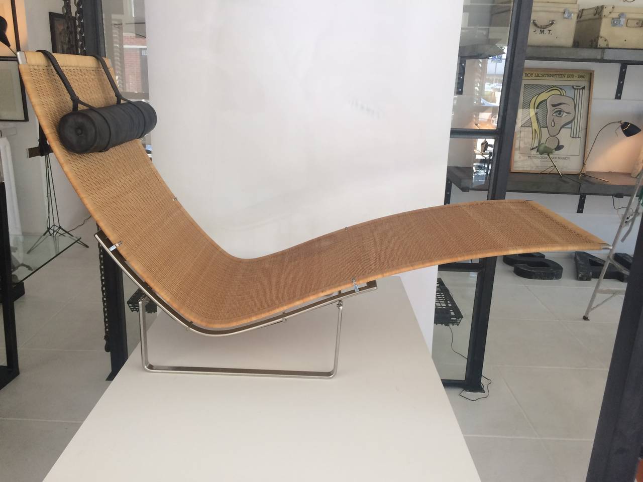 Designed by Poul Kjærholm (Danish 1929-1980). 
A stainless steel, cane, and leather lounge chair.
Model PK 24, for E. Kold Christensen, Copenhagen, Denmark, designed 1965.  The organically shaped lounge in woven cane on a stainless steel frame
