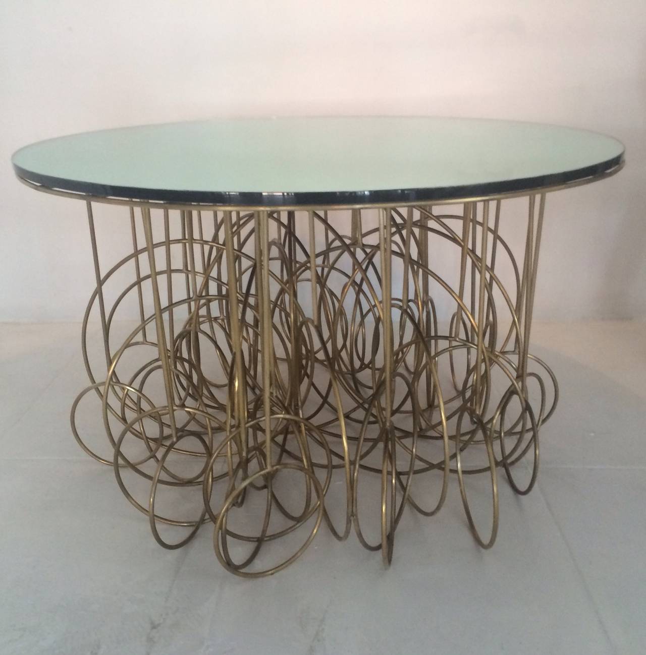 A fabulously extravagant French brass table. Top is a 3/4 inch thick straight polished mirrored glass, c.1980s