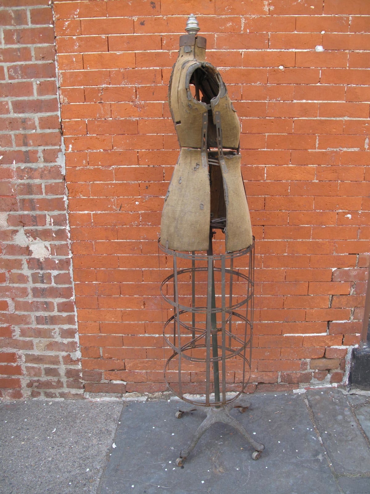 Expandable strap steel dress form. On wood casters. No apparent makers mark or label.