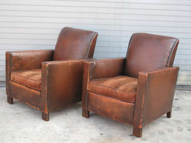 Pair of Deco leather club chairs with loose velvet cushions and block wood legs.  Leather piping on the cushions.  Clean, tailored lines.