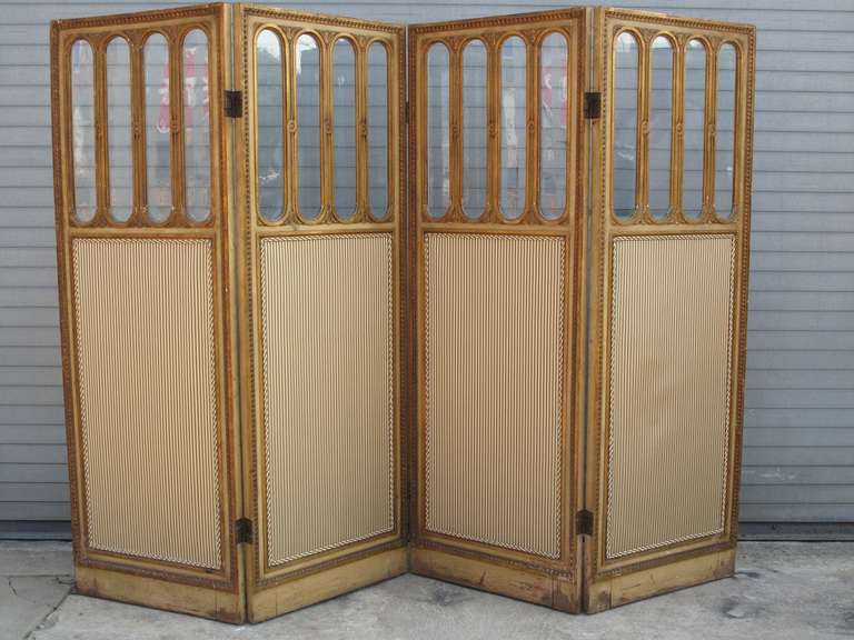 Gilded wood frame with oblong glass panels.  Front has pinstripe fabric; back side is a solid neutral.