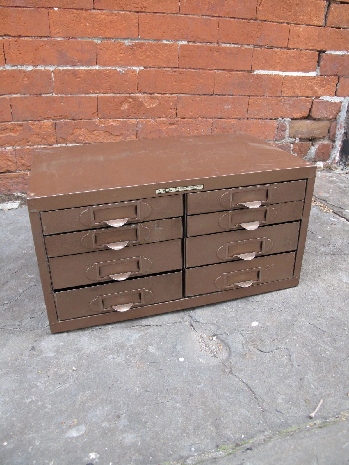 Bronze-hued metal toolbox with 8 drawers made by Model Box & Cabinet Company of Chicago, IL.