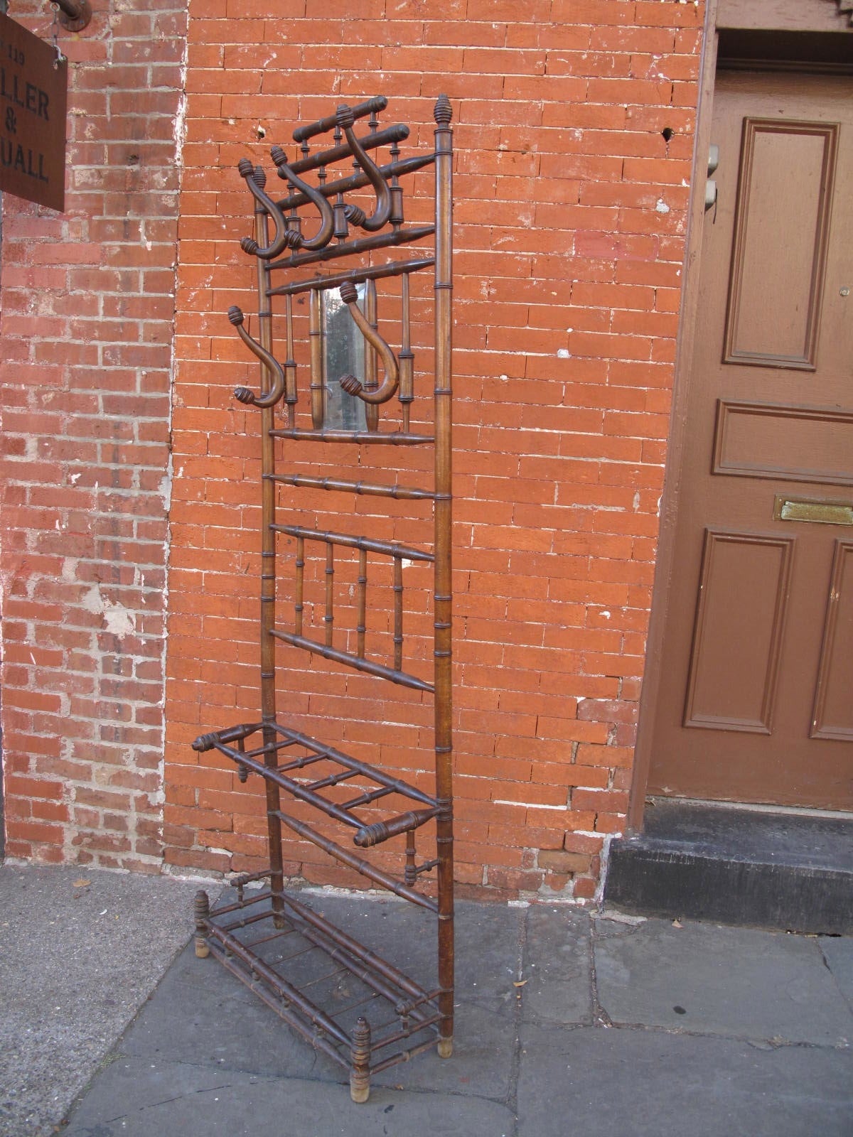 Late 19th Century English hall rack with umbrella stand at base. Carved to simulate bamboo. Hooks are able to swivel from side to side.