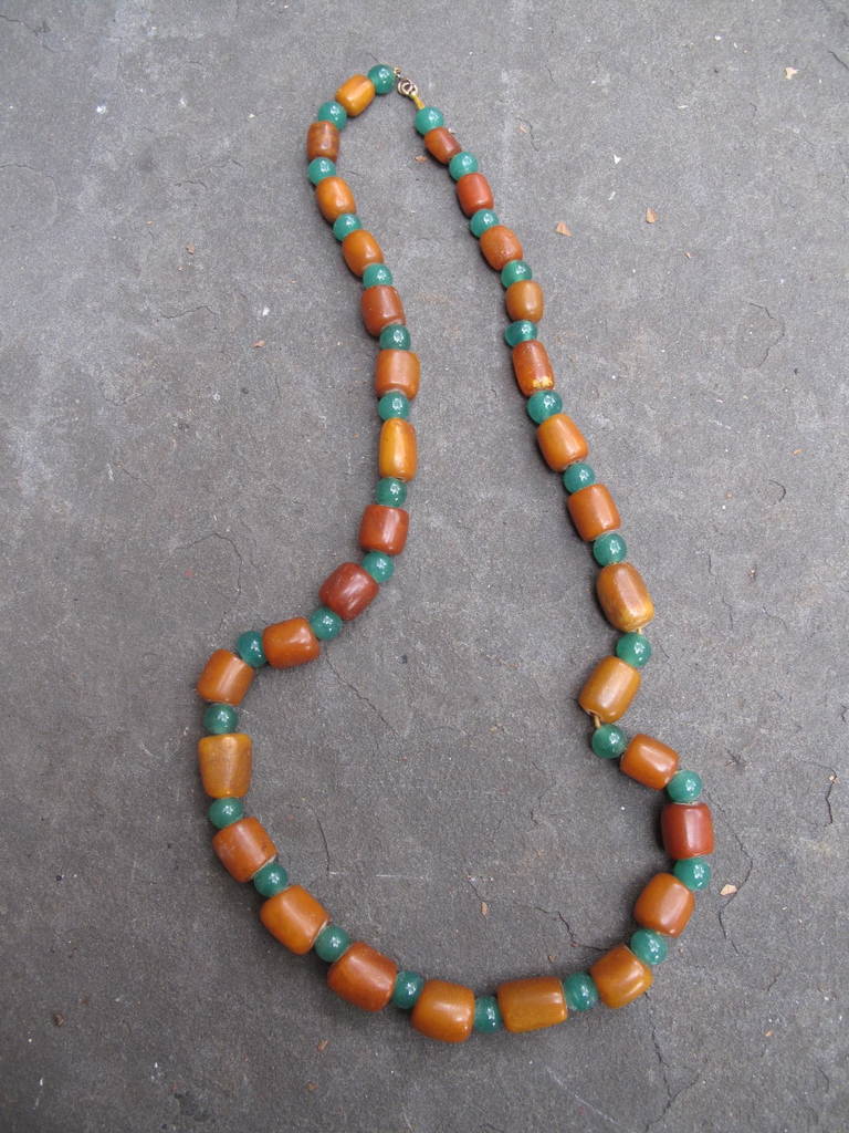 Natural color variances in these butterscotch oblong beads. Each bead is slightly different in size and shape. There are 30 amber beads in total. Intermittent antique green glass beads. Gold filled clasp. Cotton string.