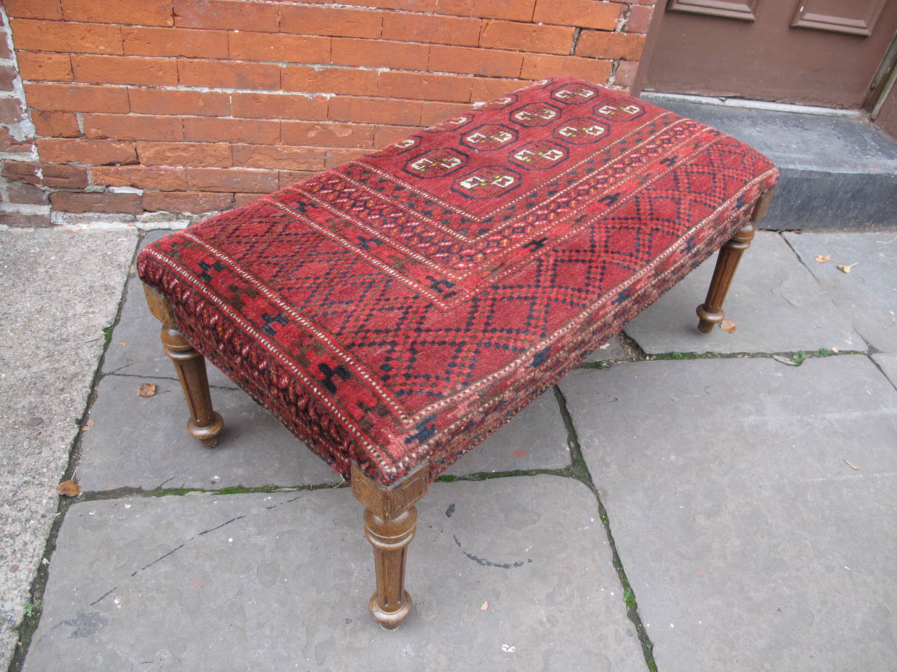 Ottoman reupholstered in vintage carpet fragment.