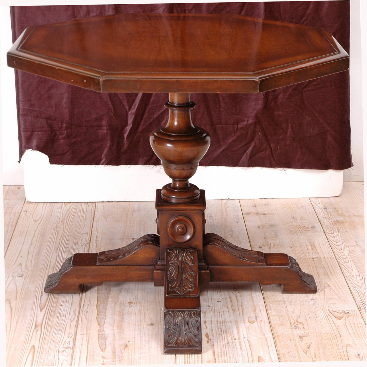 In the style of Architect Addison Mizner (1887-1933), a Renaissance-inspired walnut table with octagonal top on turned baluster resting on square base over four acanthus carved feet. A small banding with wood inlays decorates the top, American,