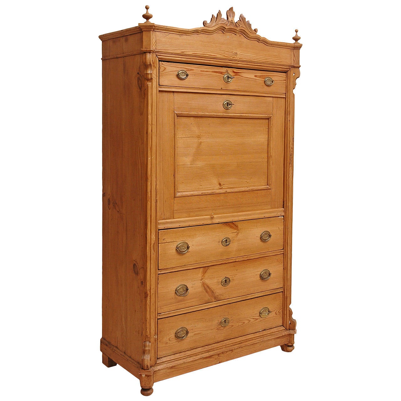 A lovely secretary in pine with four exterior drawers and fall-front opening to a series of smaller desk drawers and open cubby hole. With original carved foliate bonnet and finials.
Measures: 38 1/2