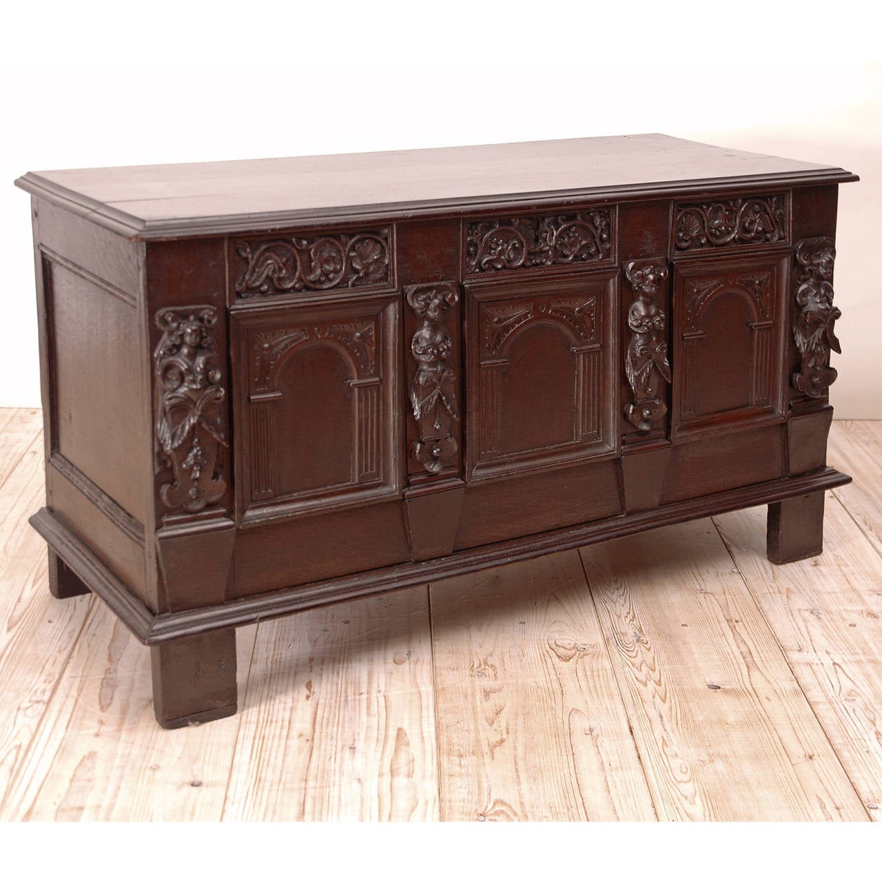 Composed of antique architectural elements which include carved female figures, arabesques and arched panels, this hinged chest made of oak has a dark and rich patina. Some of the elements appear to be from the 1700s or earlier. Lovely for use at