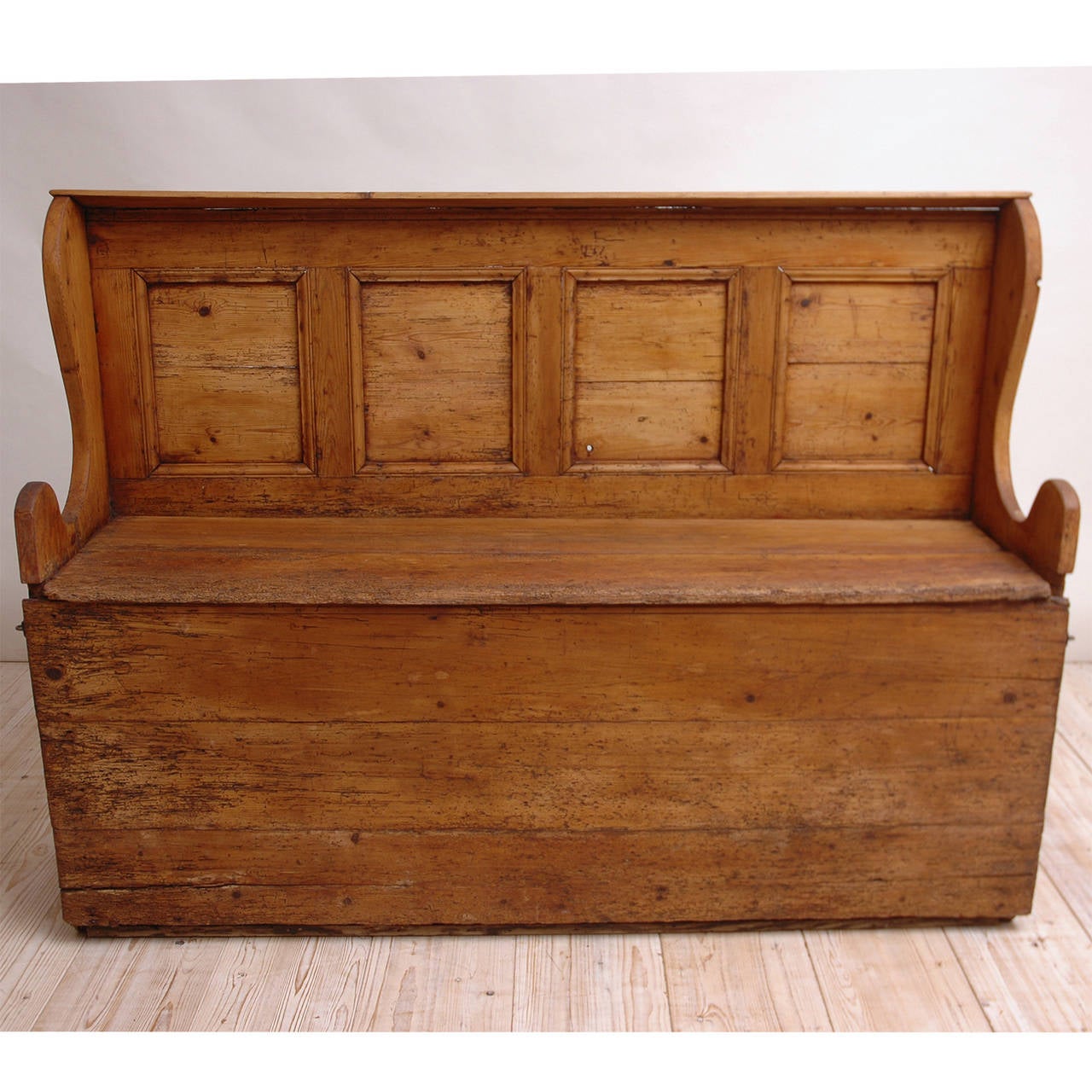 A charming pine bench with paneled back that opens to house a feather mattress for a guest, England, circa 1800. Lovely for use in a mud room, children's playroom or on a patio. Finished with tung oil which will hold up outdoors under a covered