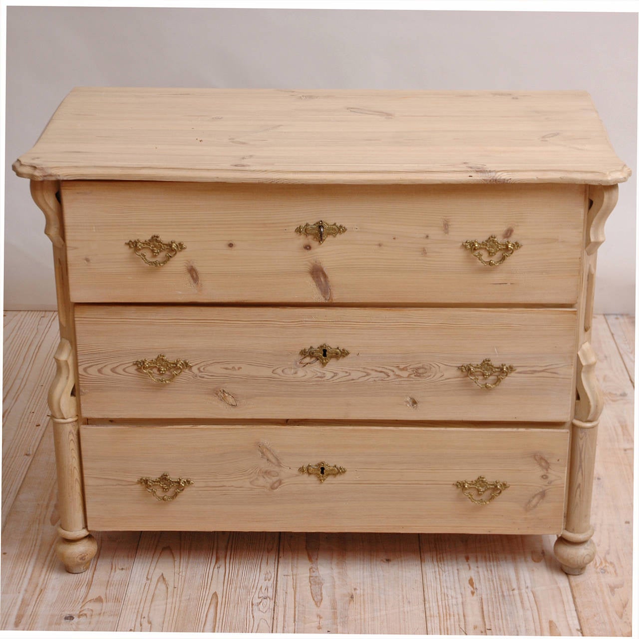 A charming chest with three drawers in pine with a limed chalk and lye finish. Offers brass pulls and key plates and working locks and key, Germany, circa 1850. May be used as a nightstand or an end table along-side of a daybed or sofa.

Measures: