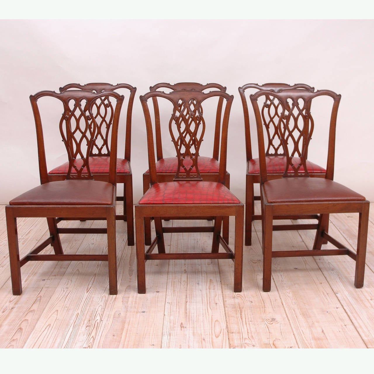 A good set of 19th century dining chairs in mahogany with serpentine crest rail, carved and pierced slat, Marlboro leg, box stretcher and drop-in upholstered seat. Two have been upholstered in brown ostrich leather and four in a fine red alligator