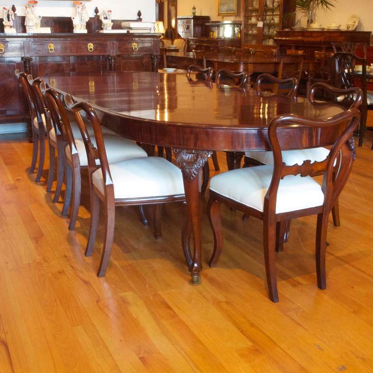 Exceptional extension dining table with racetrack top and cabriole leg with well-articulated carving of scallop and palmette on knee. Comfortably seats 10 and up to 12. Incomparable French-polished finish. Table measures 90" long closed and has