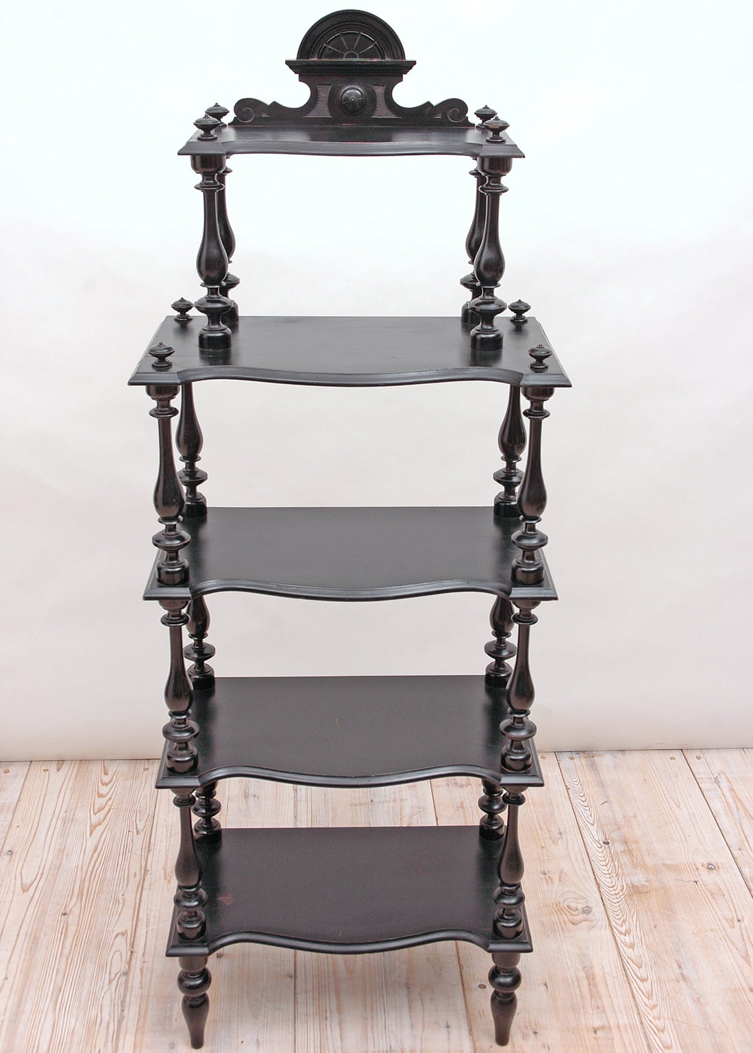 A charming Napoleon III What-not or Etagere in ebonized wood (original black painted finish) with five shelves supported by vase-ring-and-bulb turnings, with carved bonnet, and resting on turned feet. France, circa 1870.

21
