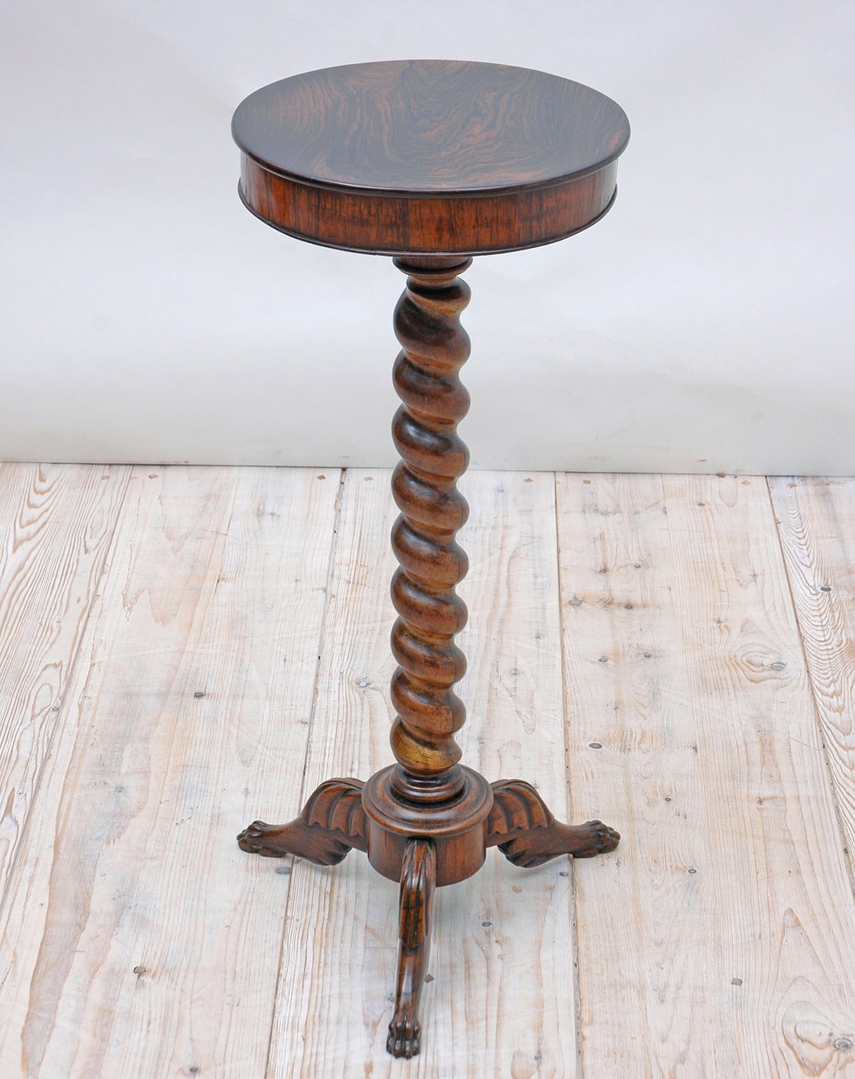 A very lovely table in fine rosewood with a round top supported by a twist-turned column resting on carved tripod feet and terminating with lions' paws, France, circa late 1800s.

Measures: 12 3/4