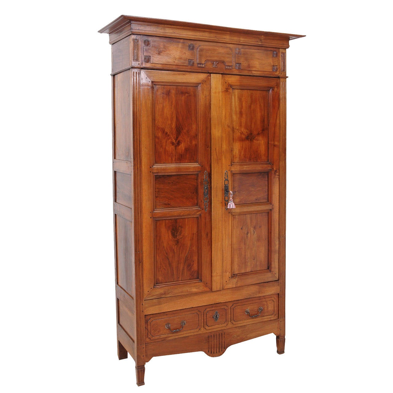 An armoire of statuesque and pleasing proportions given its narrow width and tall stature, in walnut from the Directory period in France (circa 1800). Offers original pulls and key plates, with one exterior drawer. Recent interior carpentry includes