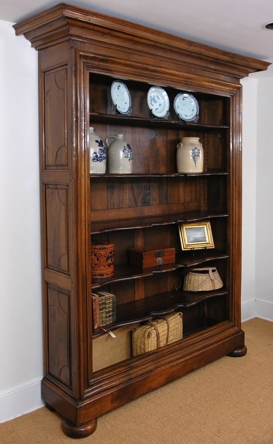 Originally an 18th century armoire from Brittany in walnut, this handsome piece was expertly modified to function as an open bookcase. An elaborate cornice along with pronounced moldings (where doors had once been) define the opening, with