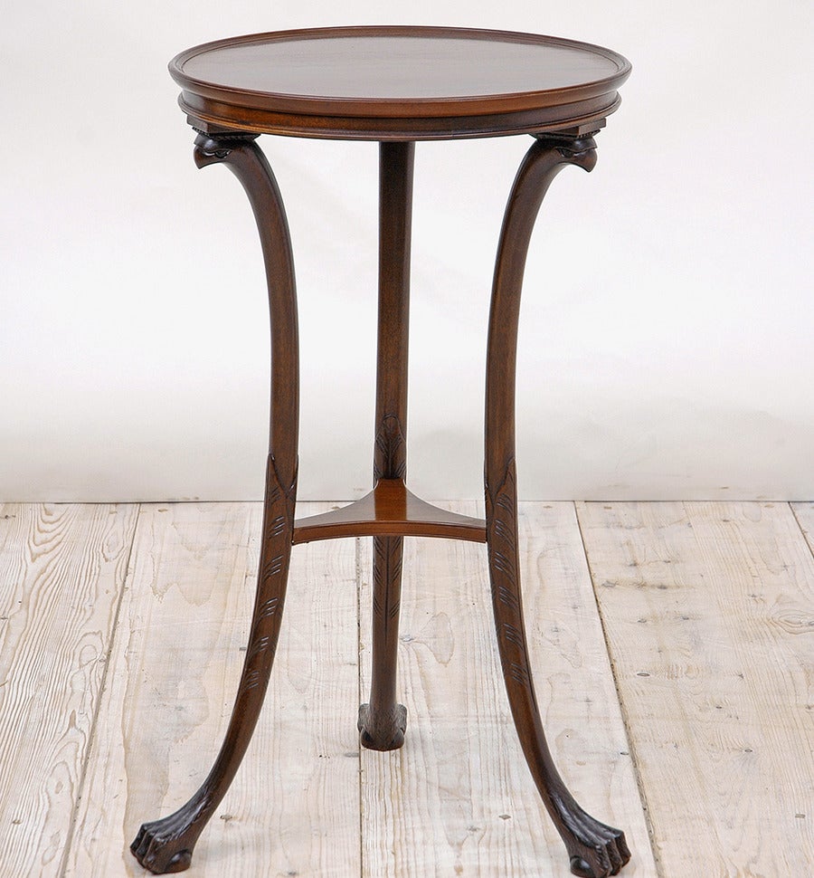Pair of round tripod tables in mahogany with monopods for legs with stream-lined carvings of eagle heads atop and ending in ball-and-claw feet, American, circa 1950. French-polish finish.

Measures: 16.25