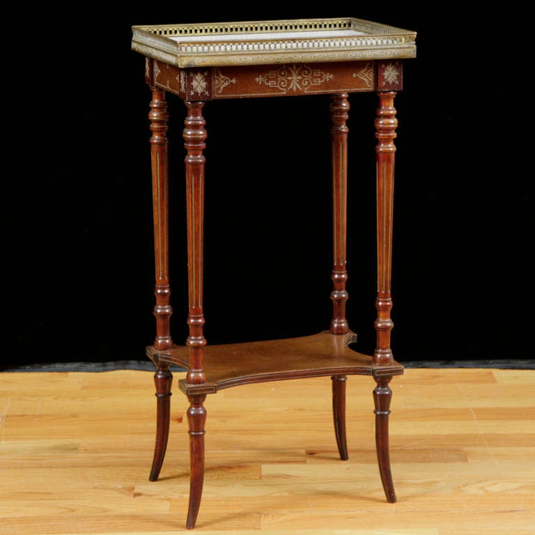 A small Napoleon III parlor table in mahogany with white marble top, brass gallery and fine brass inlays. Table rests on finely-turned and fluted legs, adjoined by a bottom shelf and ending on splayed feet. France, circa 1870. 

Measures: 16