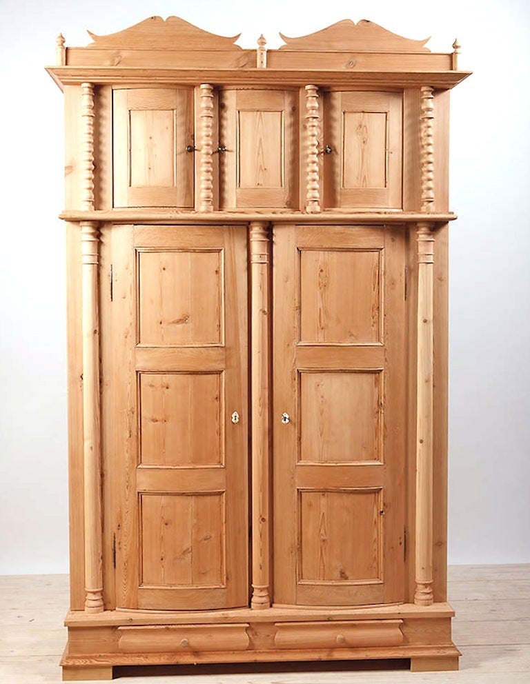 Rare five-door Danish armoire in pine with bowed-paneled doors, circa 1835. Incredible armoire offering lots of storage and charming exterior configuration. Split columns, spool turned columns, bowed doors, beautiful architectural panels and