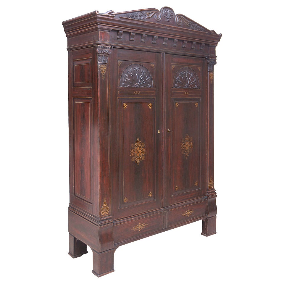 Une armoire majestueuse et rare en faux bois d'origine et décorée au pochoir d'or, avec un fronton sculpté, un motif de soleil et des chapiteaux ioniques sculptés, Brême, Allemagne, vers 1815.

Dimensions : 69
