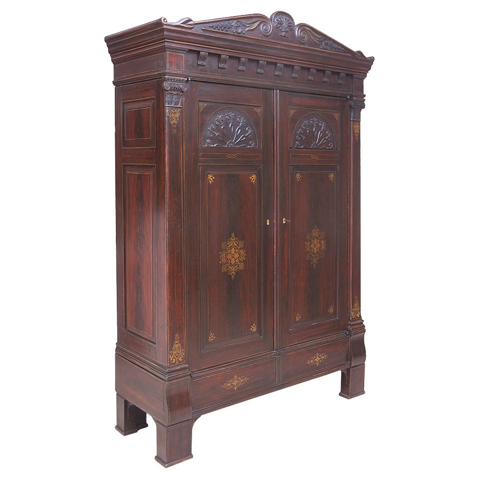 A stately and rare armoire in the original faux bois and gold stenciled finish with carved pediment top, sunburst motif and carved ionic capitals, Bremen, Germany, circa 1815.

Dimensions: 69