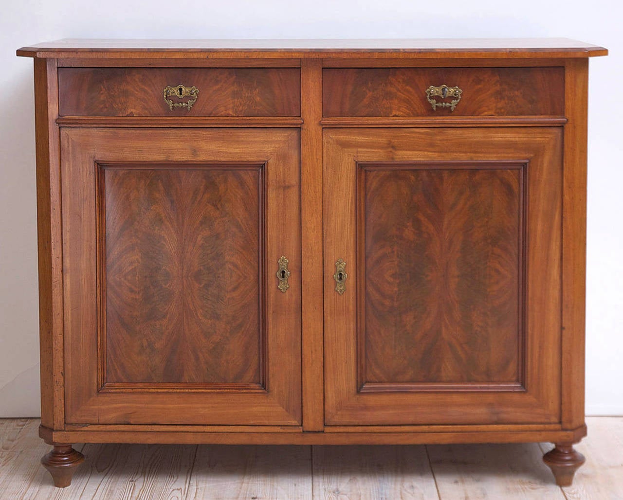 A cabinet or buffet in walnut with book-matched figured walnut on panels of two doors and drawer fronts. Offers original hardware, locks, and turned feet. Northern Europe, circa 1880.

50