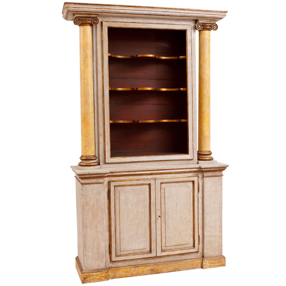 A very beautiful and tall Italian neoclassical style cabinet with polychromed finish, with open display shelves over base with two doors. This impressive cabinet is very dramatic with its faux-marble columns and carved ionic capitals, Italy, late