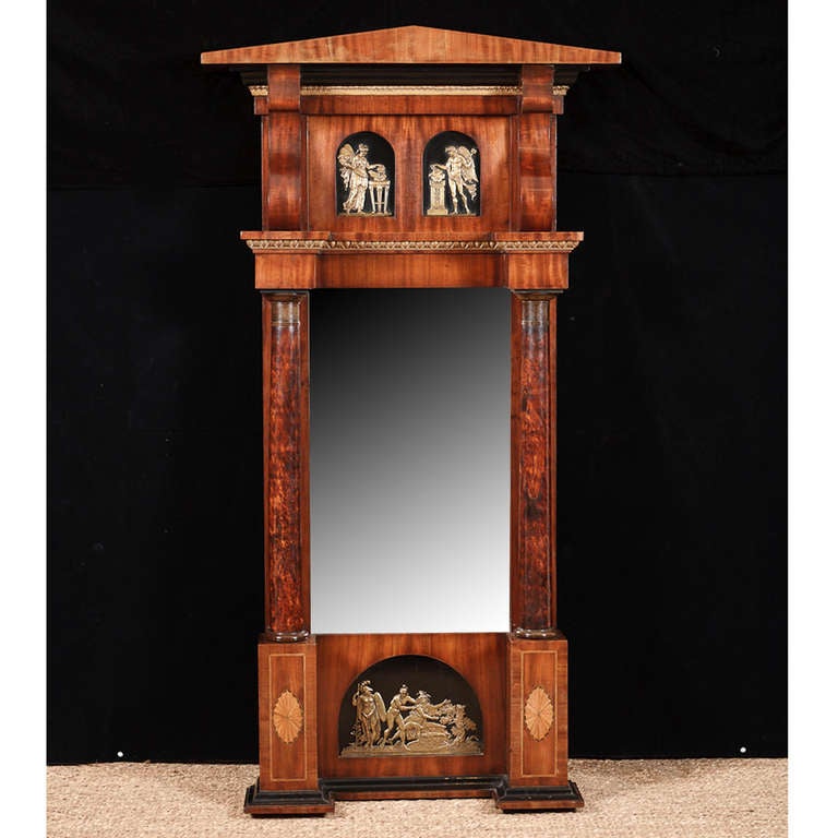 Empire mirror in mahogany with satinwood inlays and bronze D'Ore ormolu mounts, Sweden, circa 1800.
The mythological scenes depicted in relief above mirror on two arched panels are of Prometheus on the right and Pandora on the left. On the bottom