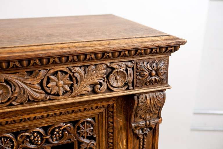 Renaissance Revival cabinet or bookcase in oak with four beautifully pierced carved door panels depicting two facing swans surrounded by grapes. Other carved motifs include acanthus leaves, scallop shells and rosettes, France, circa 1900.

80