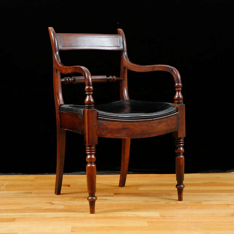 Pair of English Sheraton Mahogany Arm Chairs, c.1800, possibly late 18th century.  Both have black leather box cushions that are in excellent condition. Beautifully aged with a deep, rich patina and hard wax finish. They make great desk chairs or