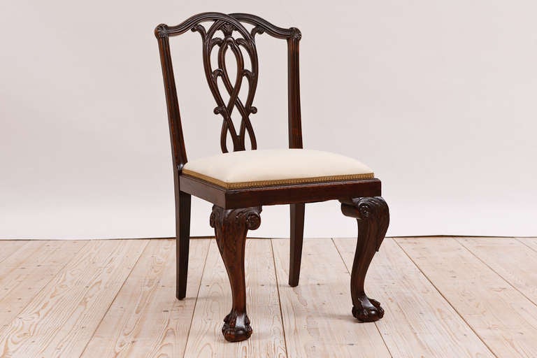 A very handsome set of 8 English Chippendale-style dining chairs in mahogany with upholstered slip seats, Colonial China, circa 1850. The carvings are very well-articulated on the pierced foliate, shield-back and on the acanthus-carved knees and