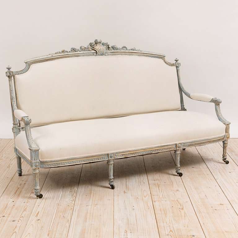 A beautiful Classic Louis XVI style sofa in polychrome finish, circa 1870 with well-articulated carvings of acanthus leaves, roses, foliage, rosettes and crest, turned and fluted legs. The unusual length makes this sofa more rare. Offers upholstered
