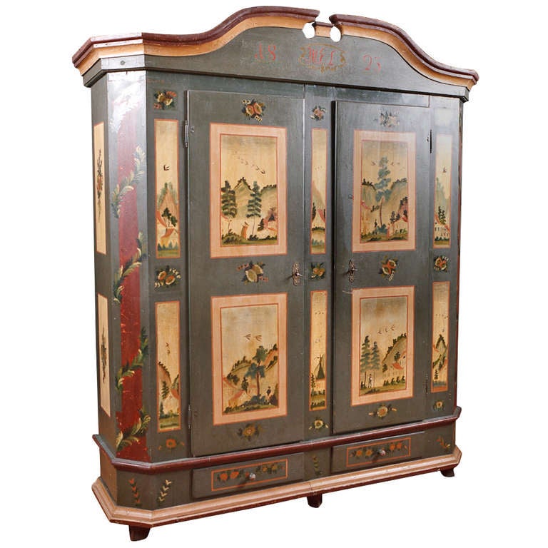 A charming dowry or wedding armoire from the Alsace-Lorraine region of France in the original paint depicting scenes in a country village with forests and mountains, church and houses, & figures dressed in Empire-style clothing. The chamfered