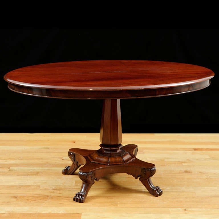 A fine center table in Cuban mahogany with oval top on beveled center pedestal resting on concave quatre-form base, terminating in carved lions' paw feet,
Northern Europe, circa 1835.

Measures: 50 1/2” long x 35” wide x 29 1/2” high.