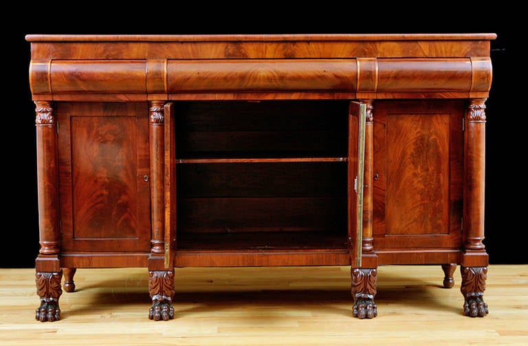 Previously listed at $10975
75.5” long x  23.5” deep x  46” high. 
This American Empire Sideboard is in mahogany with three convex drawers over four cabinet doors that are flanked by four pillars and capped with carved acanthus leaves. Base rests