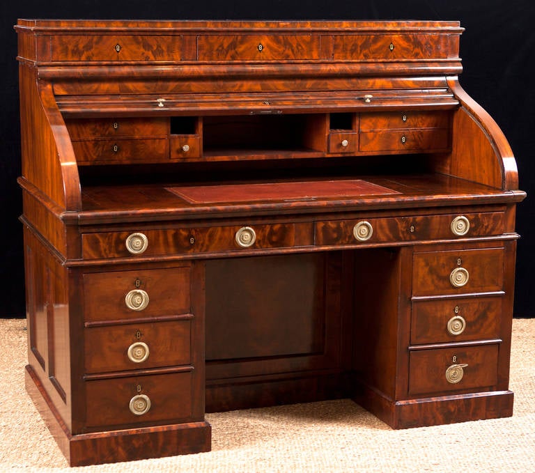 Napoleon III Pedestal Desk with tambour roll back top in bookmatched mahogany. Writing surface pulls out to make the desk very ample and comfortable. Desk has a total of 18 drawers with tooled leather writing surface. Center drawers flanking the
