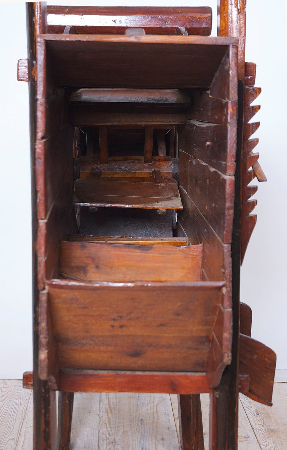 Una rara e bellissima macchina cinese per separare il grano dalla pula. Questa macchina in particolare veniva utilizzata per il riso. Realizzato in legno con decorazioni dipinte in nero, ocra e rosso, che includono motivi floreali e scene di vita