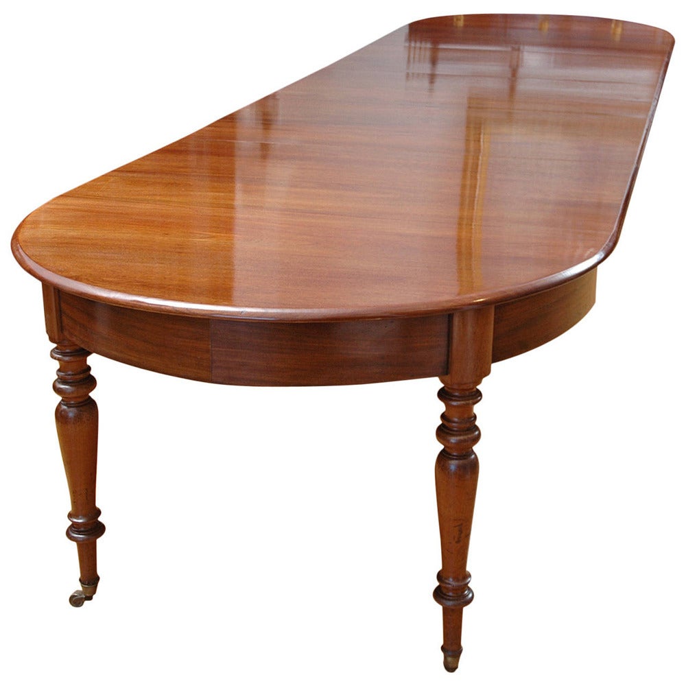 A beautiful Charles X dining table in mahogany with three leaves (new), France, circa 1830. French-polish and hard carnauba wax finish. Comfortably seats 14, with 24