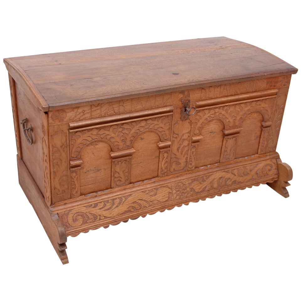 A period 18th century flat top Danish Baroque dower chest or trunk in carved oak decorated with architectural porticos and dated 1735. Offers original side handles, key plate and original iron lock with key. 
Great at the foot of a bed to store