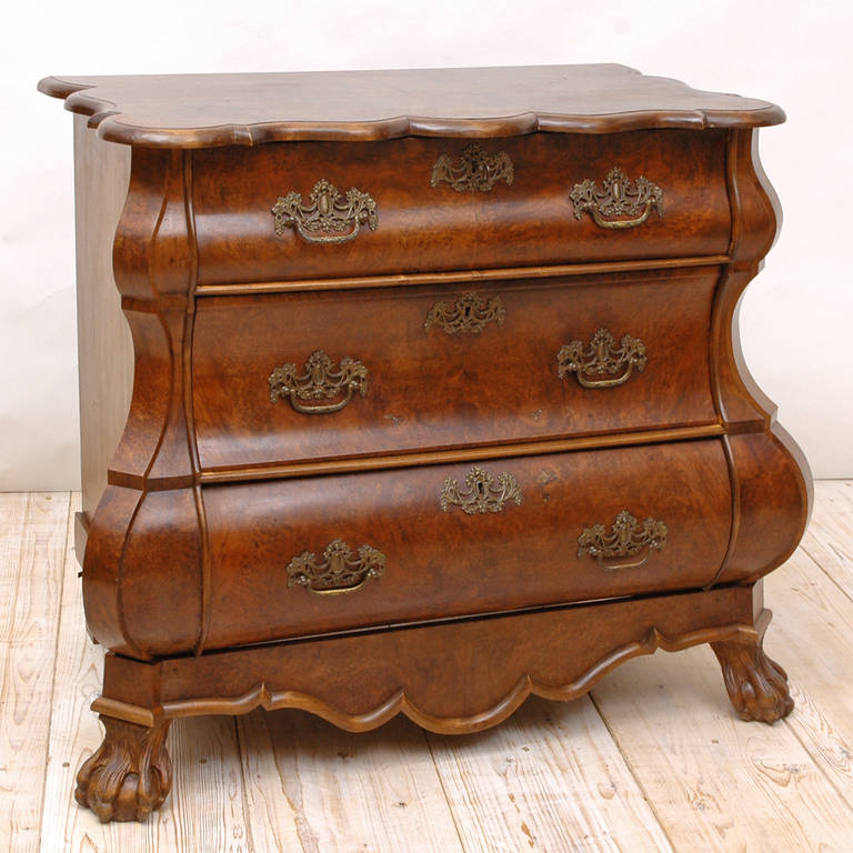 A Dutch Baroque Revival commode or chest of drawers in walnut and walnut root veneer with bombe front, brass pulls and key plates, resting on carved ball and claw feet, Holland, circa 1880.
Measure: 43