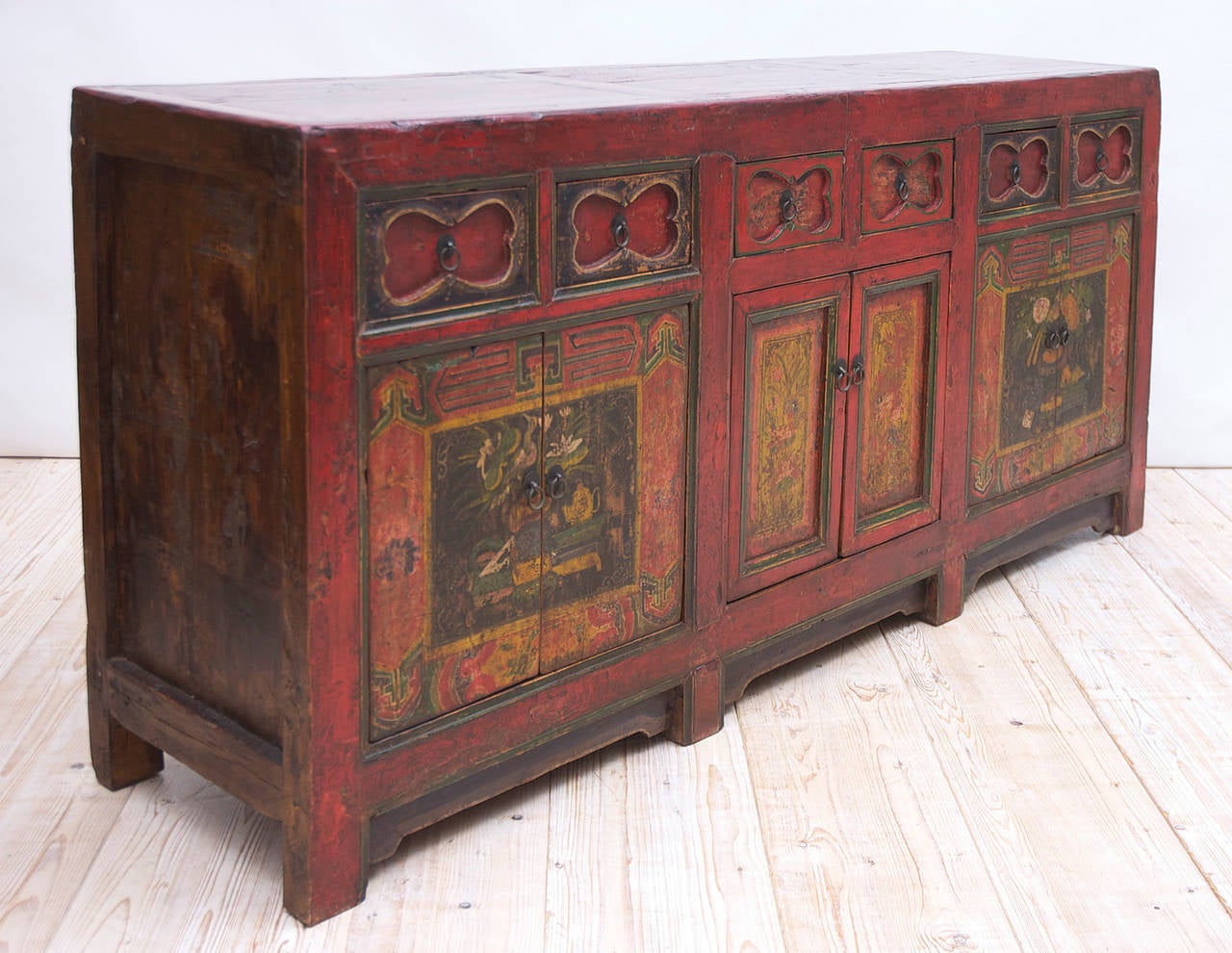 A storage coffer or sideboard with painted finish depicting still-life panels, birds and flowers in red, green and ocher tones. Western China, possibly Tibet or Mongolia, circa early 1800s or older.

Measures: 78" long x 19 1/2" deep x