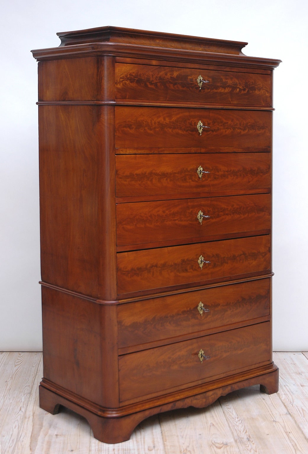A fine late Biedermeier chiffonier with pedestal top and rounded bracket feet that offers seven drawers with antique fire-gilded key escutcheons (not original), seven keys and seven working locks.

This multipurpose chest works well in a bedroom,