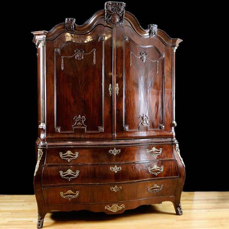 An exquisite 18th century Dutch Bombe Kast or linen press in fine Cuban mahogany with all of the original bronze d'ore mounts. From the mid-1700s, this Kast stylistically follows the period of Dutch Rococo cabinetry also refereed to as late Baroque.