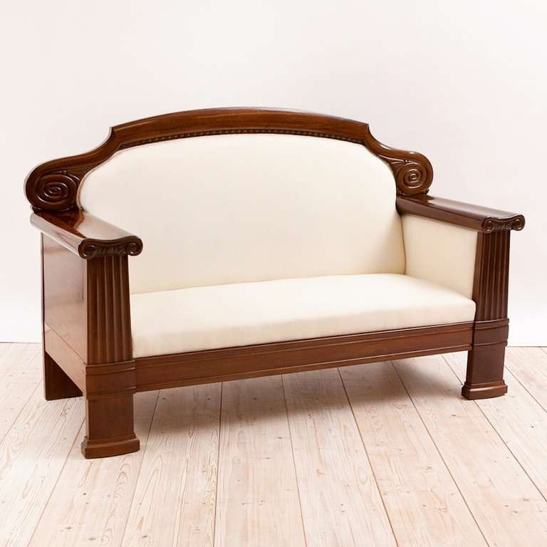 A fine Art Deco sofa in mahogany with carved, arched crest-rail and fluted pillars capped by ionic capitals on fascia of arms, Northern Europe, circa 1920.
We call this endearingly 