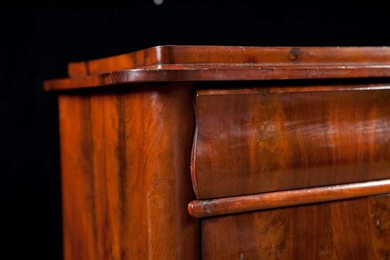 North German Biedermeier chest of drawers in figured mahogany, circa 1840.
The curved bracket foot, the shape of the top drawer face and the top molding with rounded corners fitted bellow the top are are typical of chests made in Northern Germany