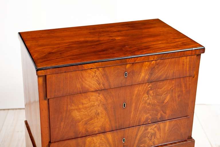 A very fine small chest of drawers that is transitioning from Empire to Biedermeier in book-matched Cuban Mahogany from Copenhagen, c. 1820. Top drawer opens to reveal lidded compartments and the original cabinetmaker's label.
Works well in a