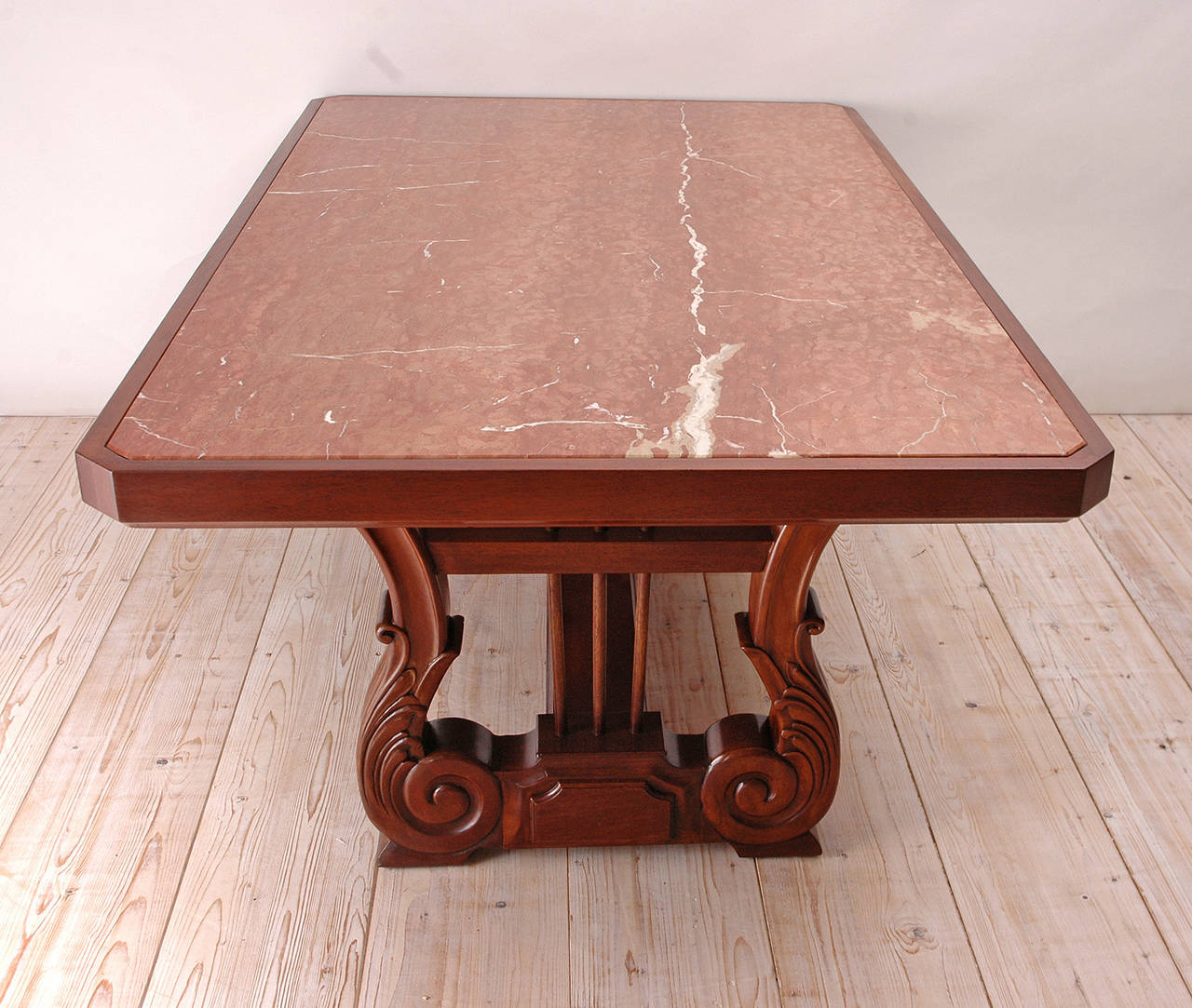 Carved Honduran mahogany table with trestle base composed of two lyres embellished with acanthus leaves and joined by a stretcher, with inset Rosso Alicante marble top. French polish finish. Custom-built in the early 1970s.

Measures: 75