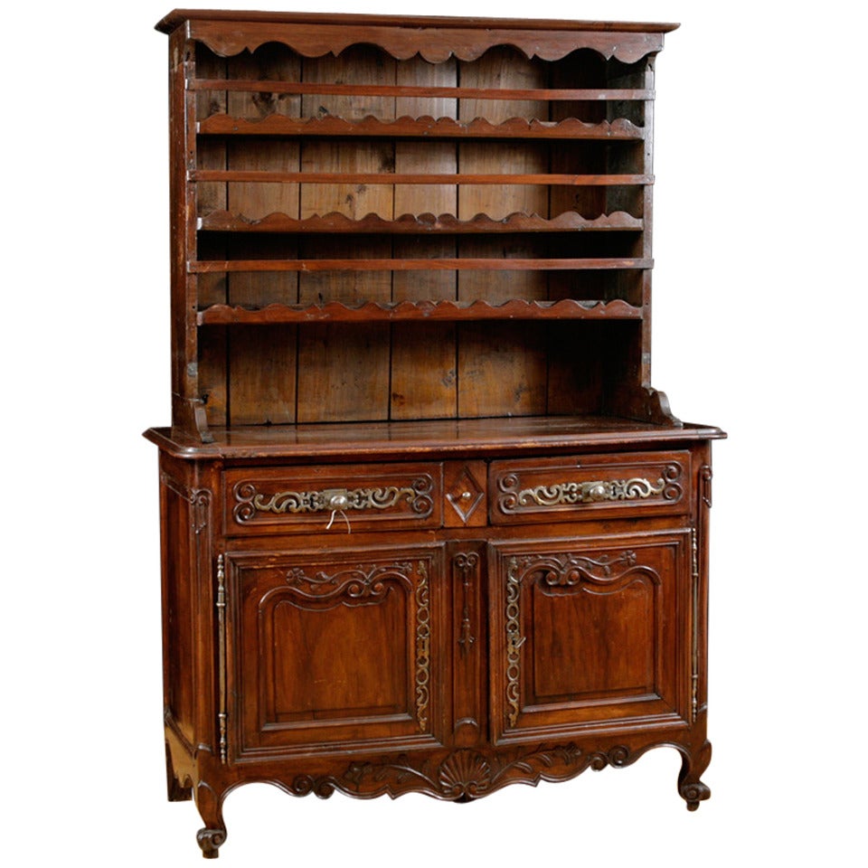 A very fine 18th century Louis XV vaisselier in walnut with beautifully articulated carvings around drawer and door panels and apron, which include a scallop shell and floral motifs. Has original period pulls, key plates, locks and original escargot