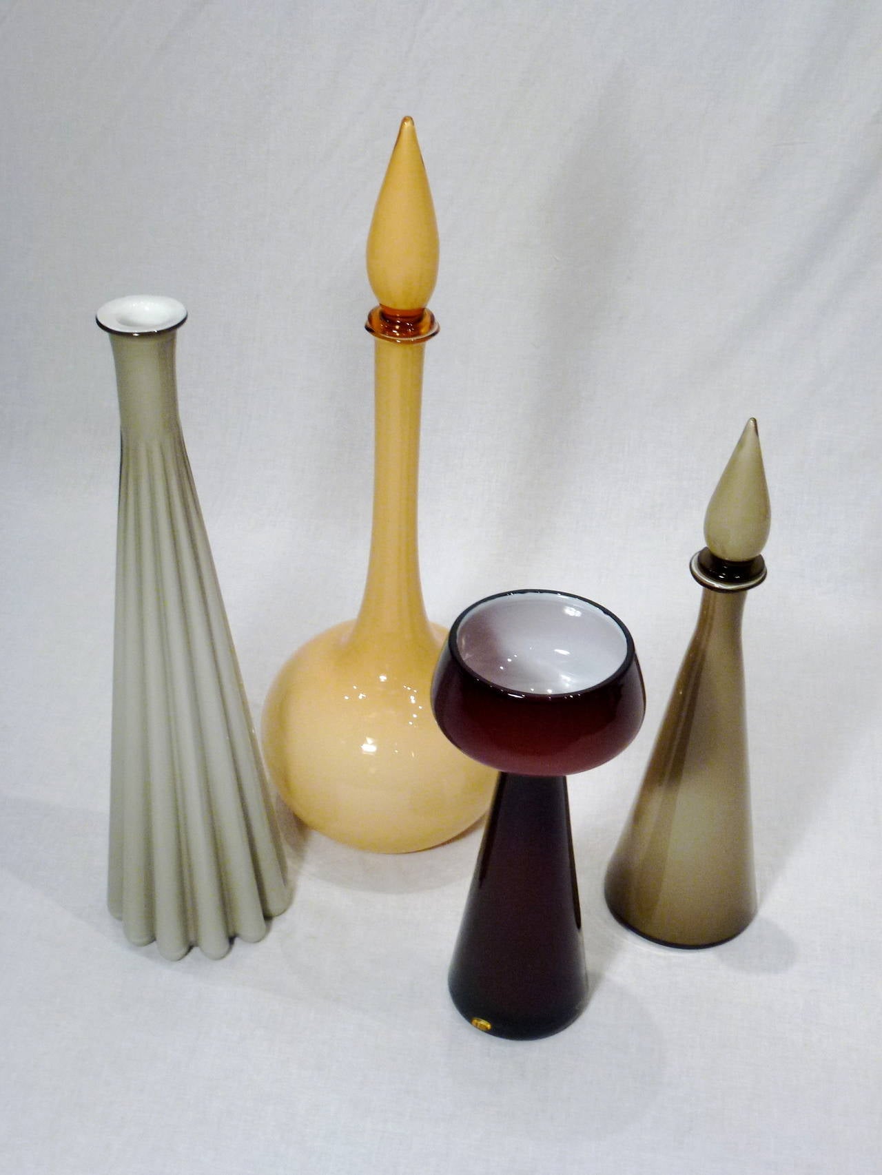 Stunning and diverse set of four Empoli cased glass decanters from Italy. The Technique of layering different color glass is referred to as casing.

Dimensions are for largest decanter. Others are 20
